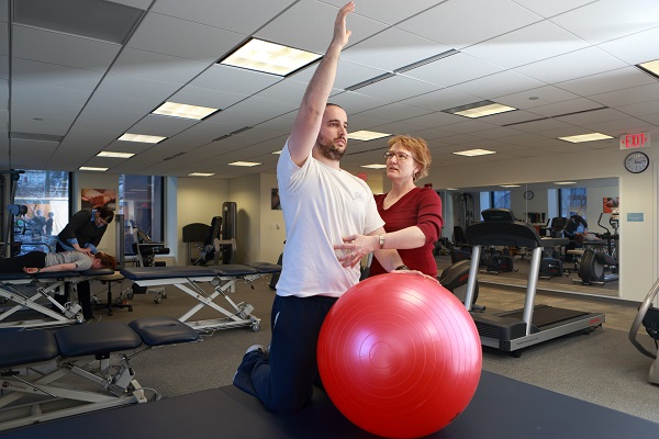 Kathryn Mitchell, PT, DPT, NCS working with a male patient in the gym